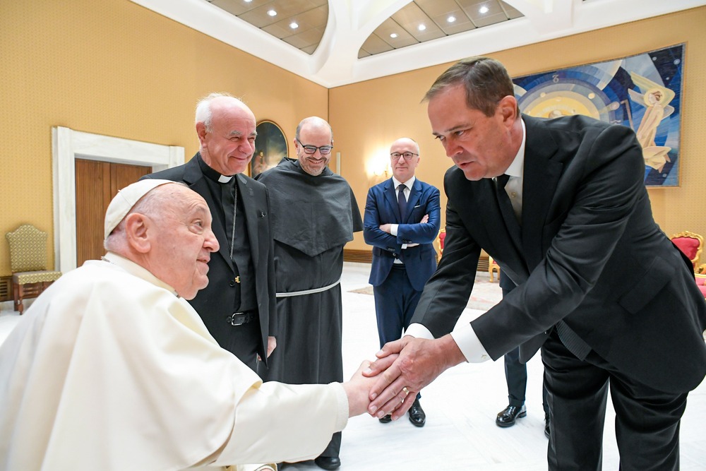 Chuck Robbins bends to shake Pope Francis' hand