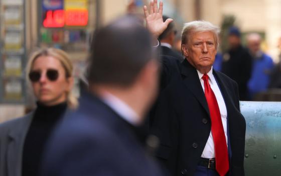 Former President Donald Trump motions as he departs 40 Wall Street in New York City after a news conference, March 25, in New York. 