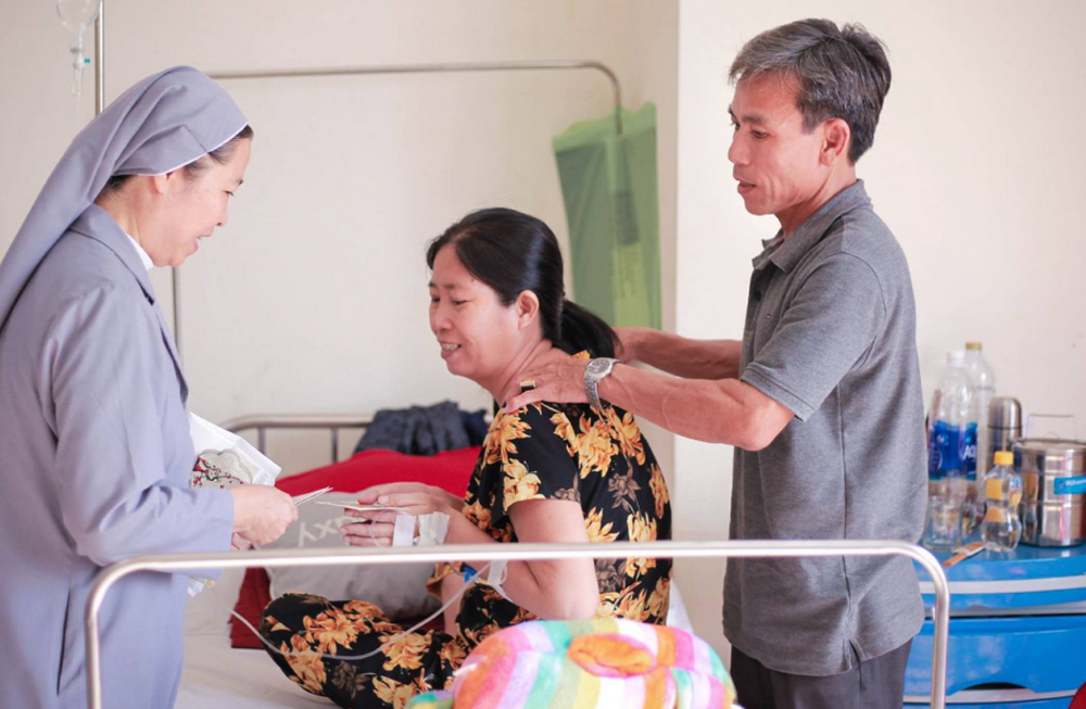 Sr. Anna Dang Thi Nhung visits and gives gifts to a patient at her house in Hue on March 10, 2024. 