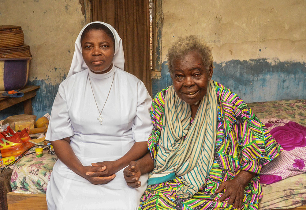 On Jan. 31, Sr. Cordelia Anekwem of the Tertiary Sisters of St. Francis sits with Elizabeth Miami, an elderly woman left alone by her family in Gboko, Nigeria. (GSR photo/Valentine Benjamin)