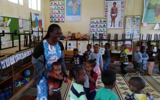 Woman in a Kindergarten room surrounded by children
