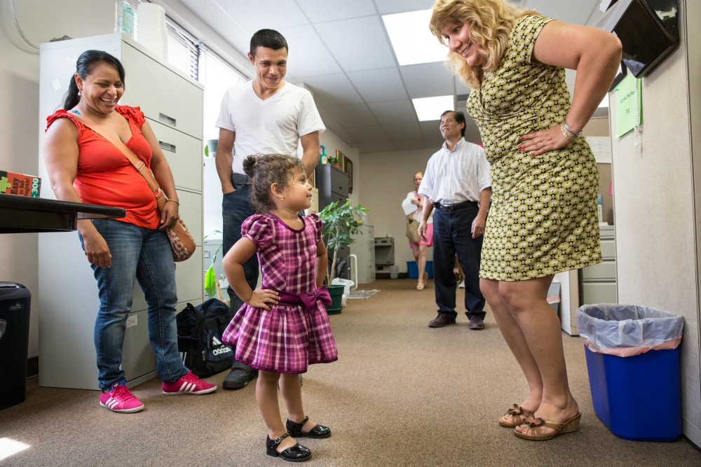 A family who immigrated from El Salvador meets with immigration caseworker Silvia Martinez, right, at the Catholic Charities office in St. Louis in 2015. (CNS/St. Louis Review/Lisa Johnston) 