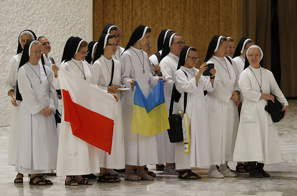 Nuns hold the national flags of Poland and Ukraine as they prepare to greet Pope Francis during his general audience in the Paul VI hall at the Vatican Aug. 3, 2022. (CNS/Paul Haring)