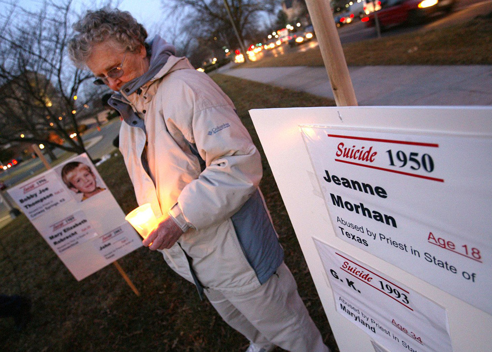 Zoe Carpenter of Germantown, Maryland, listens as the names of those who had been sexually abused by clergy and who later died by suicide are read during a candlelight vigil outside the Catholic University of America in Washington, D.C., Feb. 27, 2004. (CNS/Nancy Wiechec)