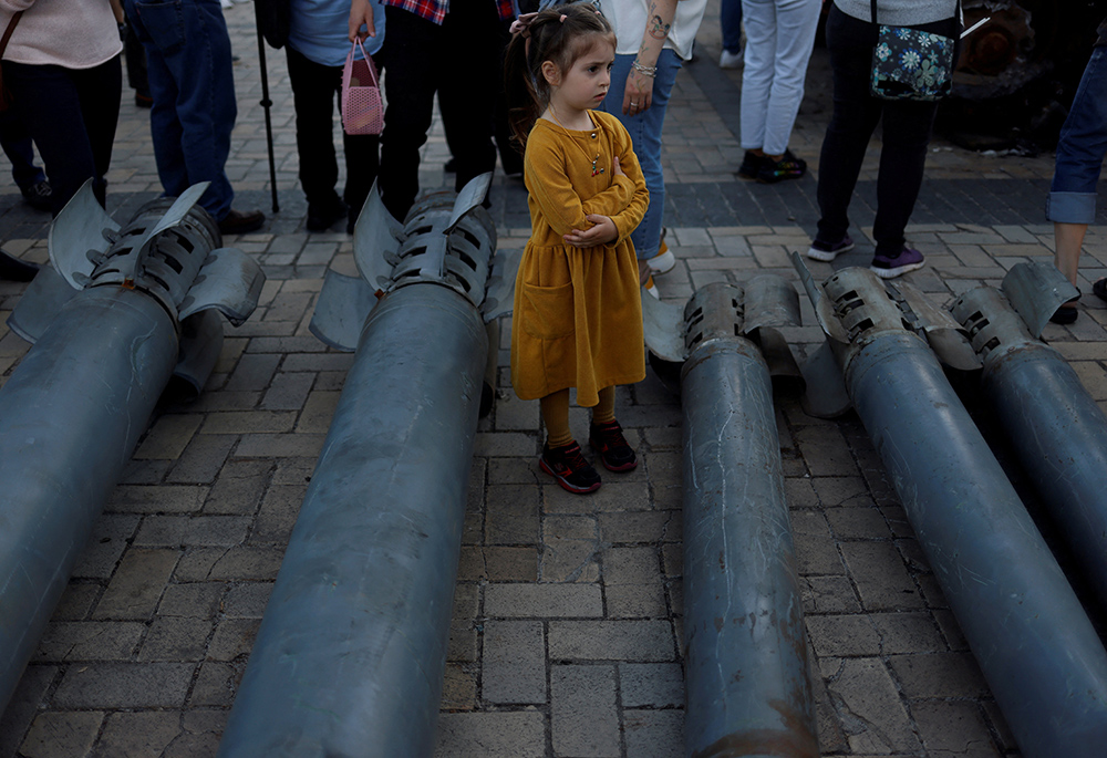 A girl looks on at a display of Russian weapon systems used in their attacks, outside St. Michael's Cathedral May 29, 2022, in Kyiv, Ukraine. (CNS/Reuters/Edgar Su)