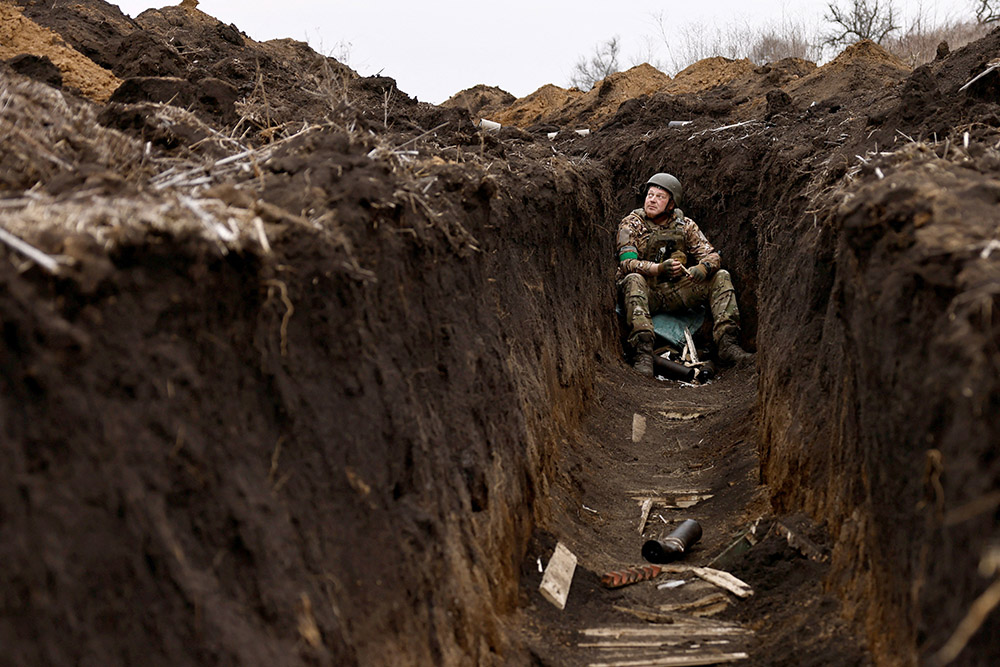 A Ukrainian soldier listens to artillery fire from his bunker at a front-line position near Bakhmut March 16, 2023, amid Russia's attack on Ukraine. (OSV News/Reuters/Violeta Santos Moura)