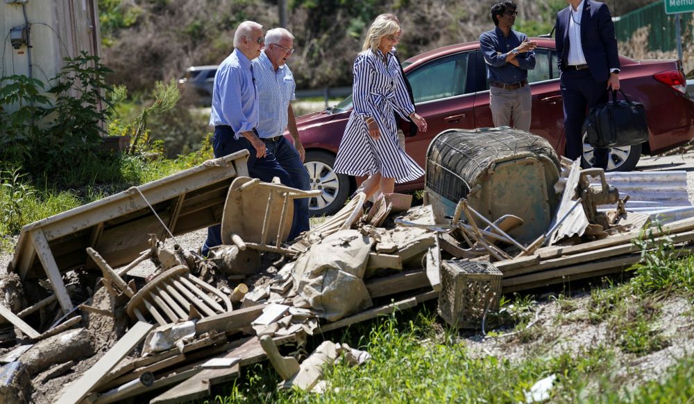 President Joe Biden and first lady Jill Biden walk past debris while viewing flood damage and response efforts in Lost Creek, Ky., Aug. 8, 2022. 