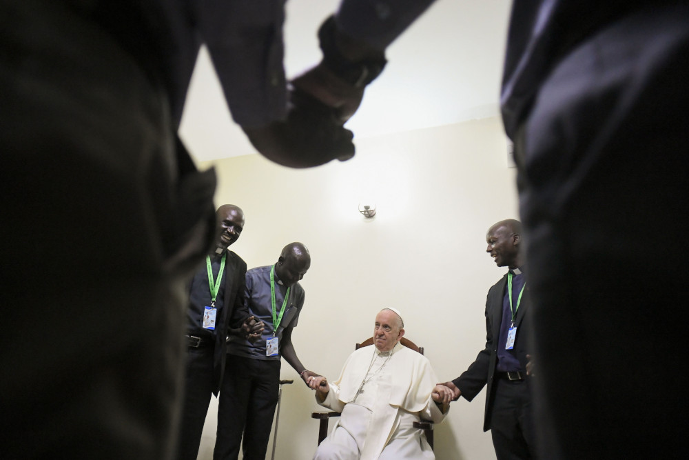 Pope Francis holds hands and prays with a dozen Jesuits working in South Sudan during a meeting Feb. 4, in Juba. (CNS/Vatican Media)