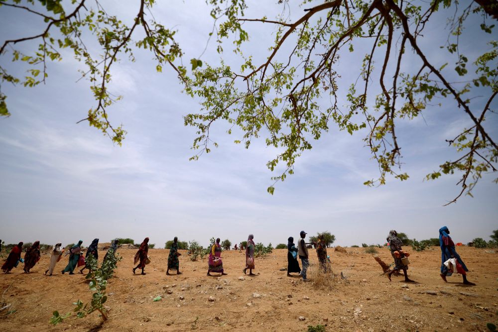 Sudanese refugees who have fled the violence in their country walk in line in Koufroun, Chad, to receive food rations May 9, 2023, from the World Food Program near the border between Sudan and Chad. 