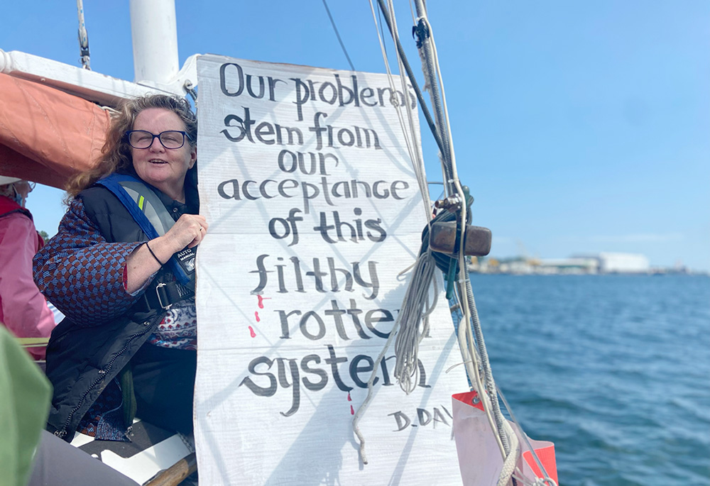 Theresa Allen of the Hartford Catholic Worker in Hartford, Connecticut, holds a sign aboard the Golden Rule. (Courtesy of Jacqueline Allen-Douçot)