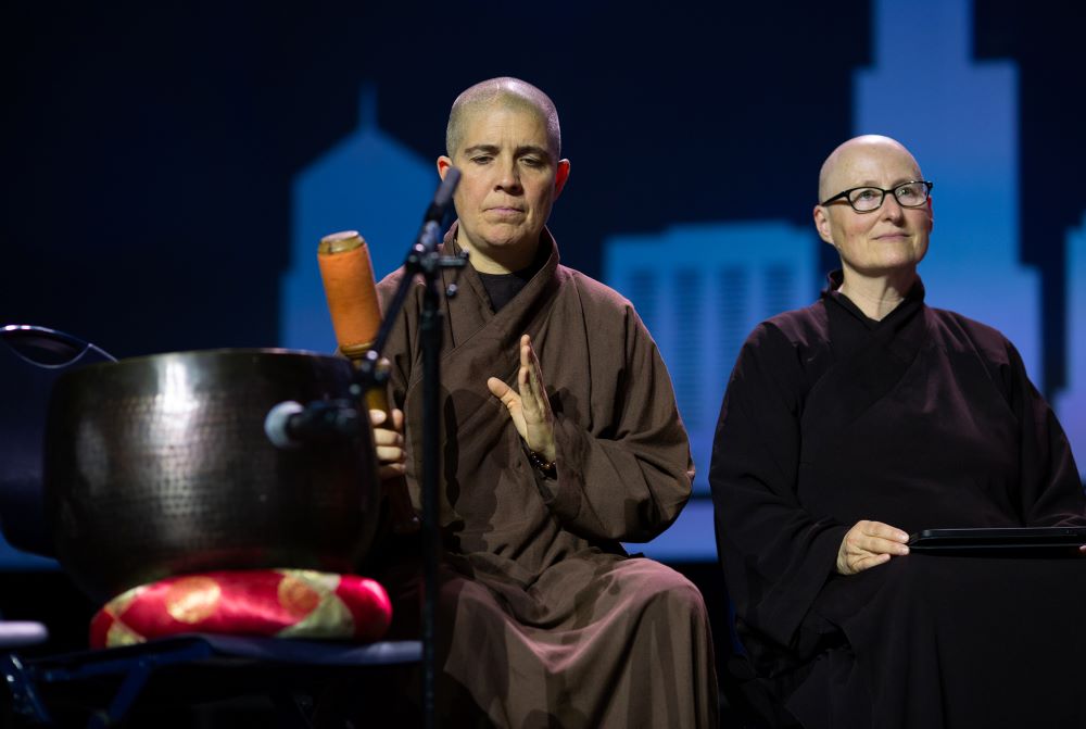A Buddhist nun from the Plum Village Monastery rings a singing bowl to mark the conclusion of different speeches at the Parliament of the World’s Religions’ climate repentance ceremony in Chicago on Aug. 15, 2023.
