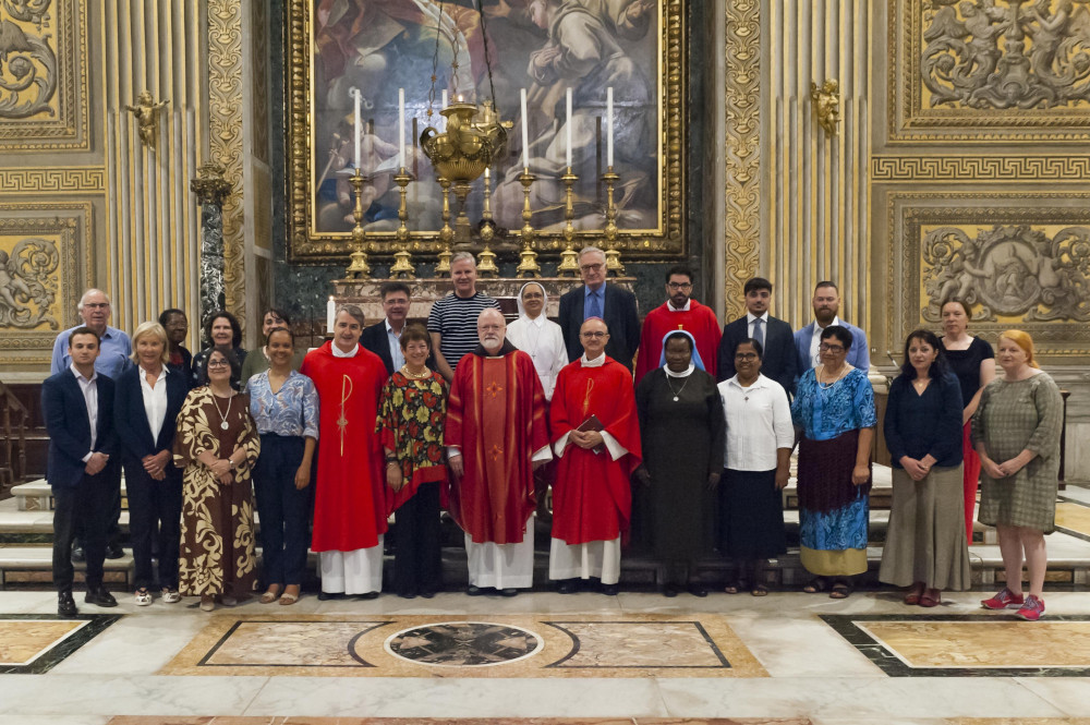 A group of people including prelates, sisters and lay people pose for a picture in an ornately decorated space