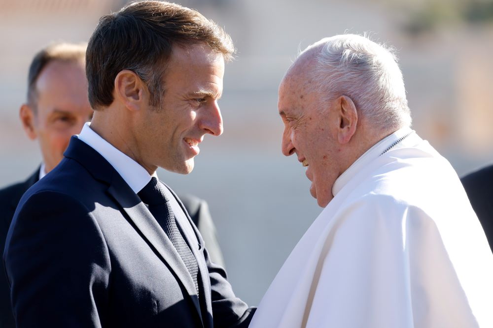 French President Macron greets Pope Francis.