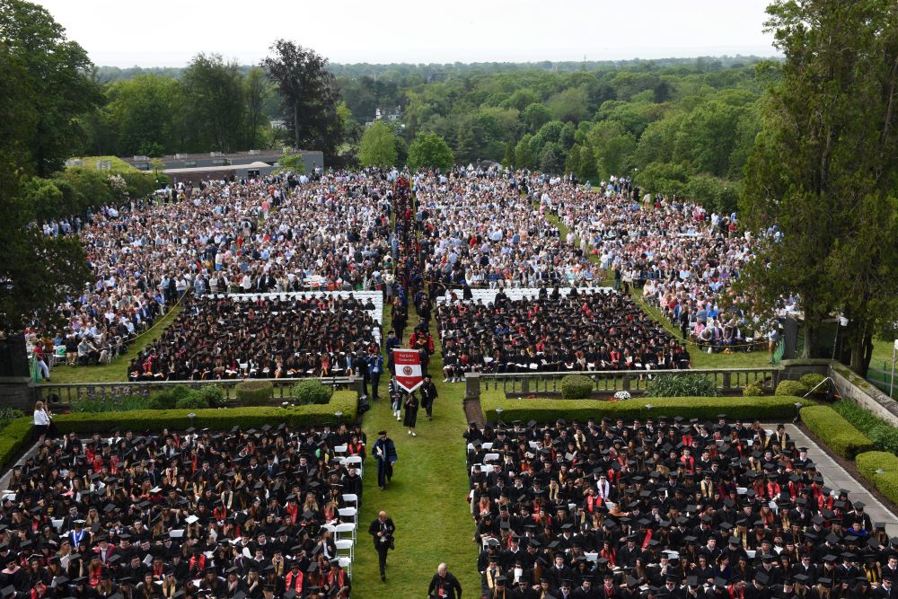 crowds at an outdoor commencement ceremony, seen from above