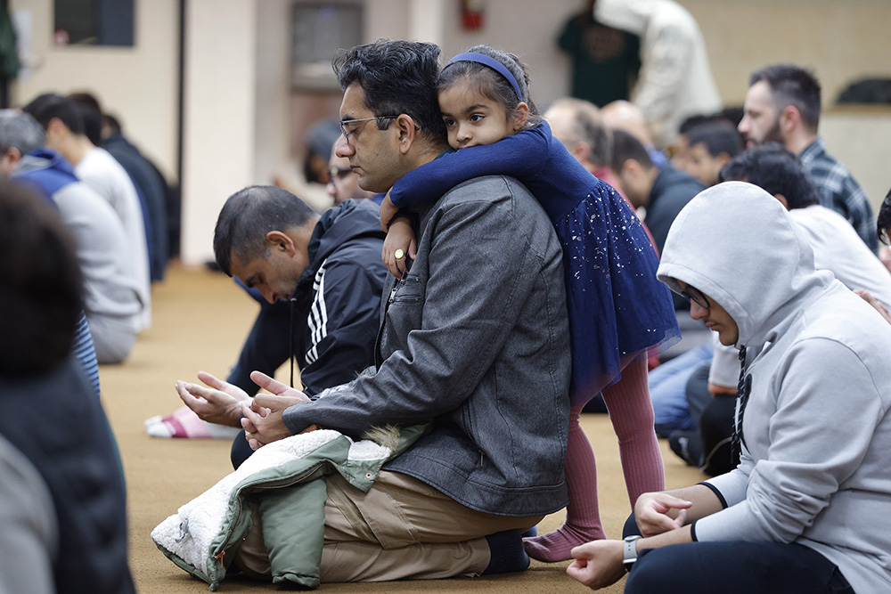 Yasir Nawaz's daughter, Amal, 4, clings to him during Friday prayers Oct. 13 at the Islamic Center of East Lansing in Michigan. (AP/Al Goldis)