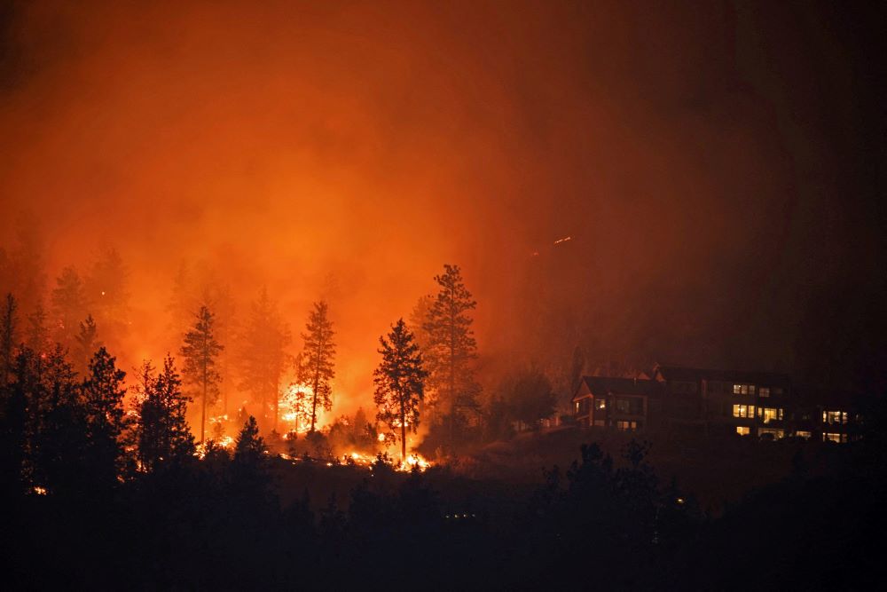 The McDougall Creek wildfire burns near homes outside the Okanagan community of West Kelowna, British Columbia, Aug. 18, 2023. 
