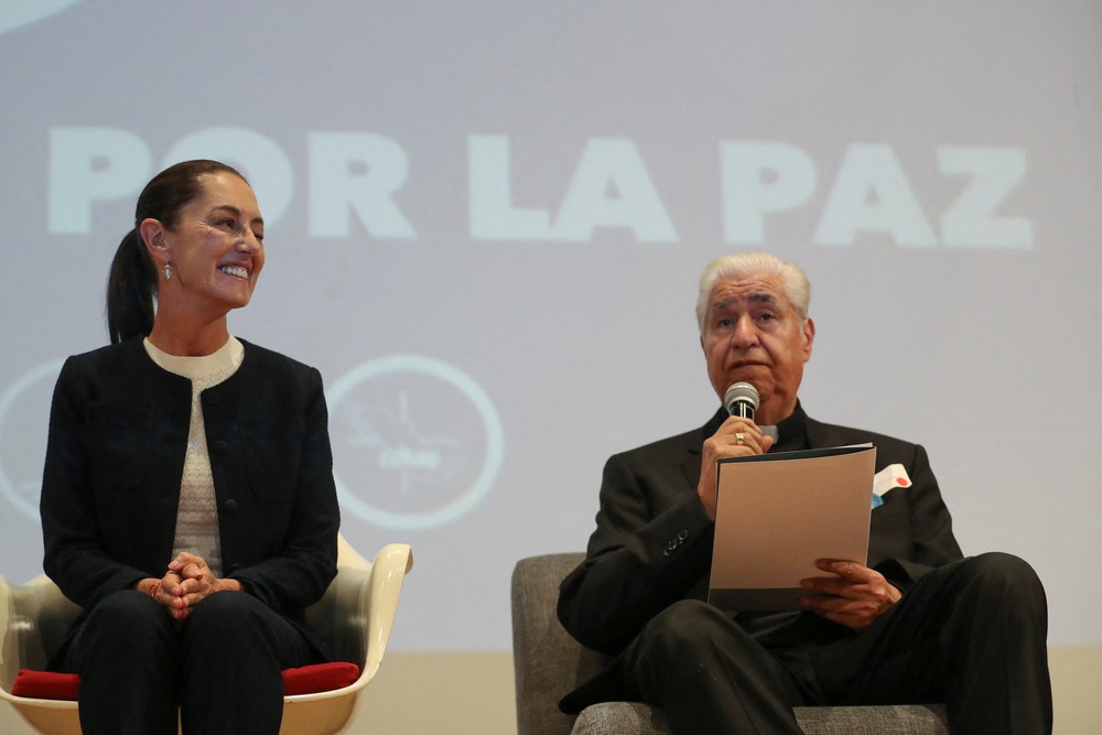 Presidential candidate Claudia Sheinbaum of Mexico's ruling party smiles as Archbishop Rogelio Cabrera López of Monterrey speaks March 11, 2024, during an event in Mexico City to sign a peace commitment organized by members of the Catholic Church.
