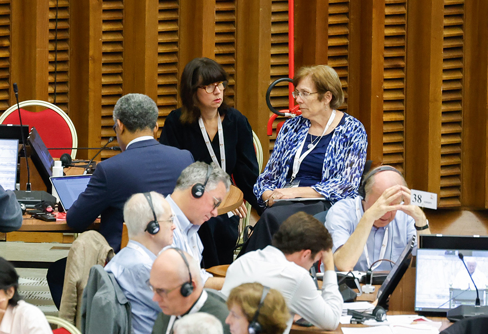 Anna Rowlands, left, a theologian from England, attends a working session of the assembly of the Synod of Bishops in the Vatican's Paul VI Audience Hall Oct. 18, 2023. (CNS/Lola Gomez)