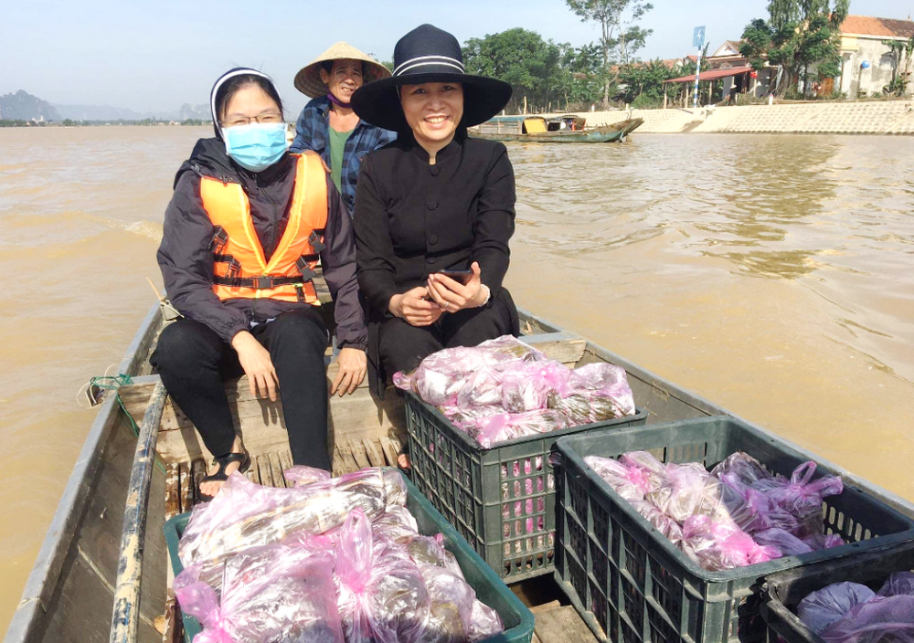 Srs. Anna Nguyen Thi Hong (left) and Anna Nguyen Thi Bich Nguyet travel by boat to give food to flood victims in areas of Vietnam in November.