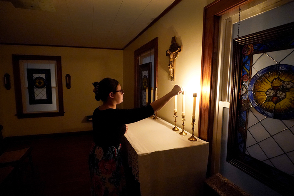 Benedictine College student Hannah Moore extinguishes candles after evening prayers with her roommates in a room which they converted to a chapel in the house they share Dec. 3, 2023, in Atchison, Kansas. (AP/Charlie Riedel)