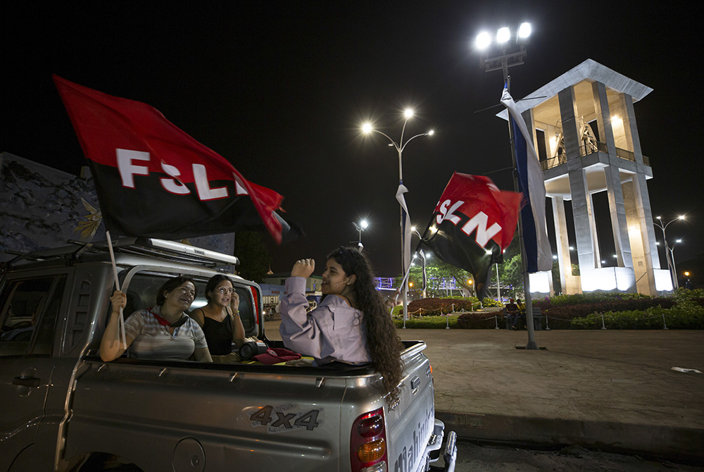 Women wave Sandinista National Liberation Front flags July 18 during commemorations for the 42nd anniversary of the triumph of the 1979 Sandinista Revolution that toppled dictator Anastasio Somoza in Managua, Nicaragua. (AP Photo/Miguel Andrés)