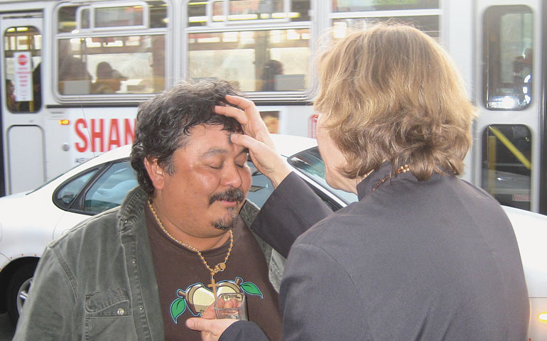 Author Sara Miles distributes ashes on a sidewalk in San Francisco on Ash Wednesday in 2010, the year the tradition began. (Claire Blackstock)