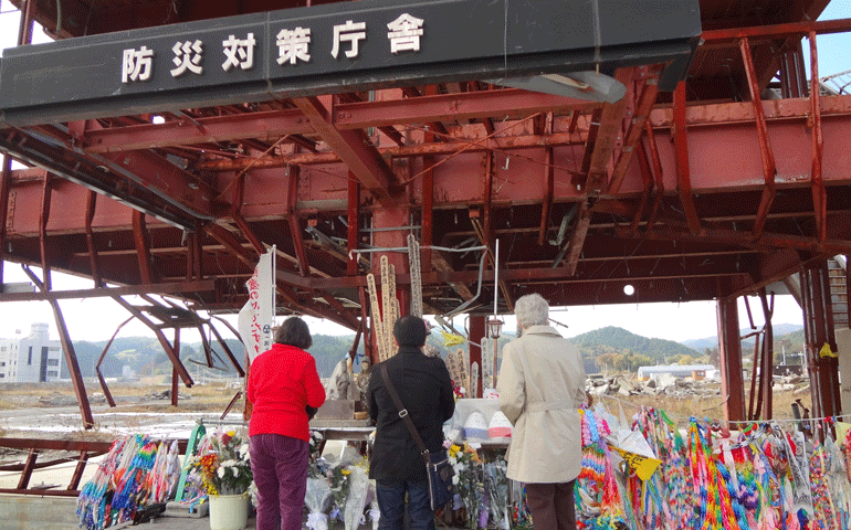People pray at the site of the radio station where a broadcaster remained to warn others and died herself during the 2011 tsunami. (Janice McLaughlin)