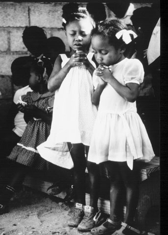 “Girls Praying During Church Service, Port-au-Prince, Haiti” (Mev Puleo)