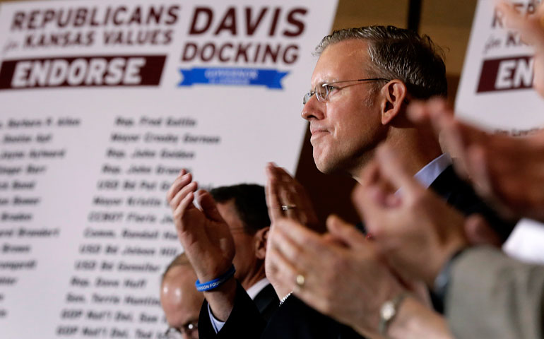 Paul Davis, Democratic candidate for Kansas governor, listens during a news conference announcing endorsements by more than 100 current and former Republicans politicians July 15 in Topeka, Kan. (AP Photo/Charlie Riedel)