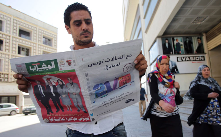 A Tunisian man reads a newspaper in Tunis Oct. 10, a day after it was announced that the National Dialogue Quartet would receive the 2015 Nobel Peace Prize. (Newscom/EPA/Mohamed Messara)