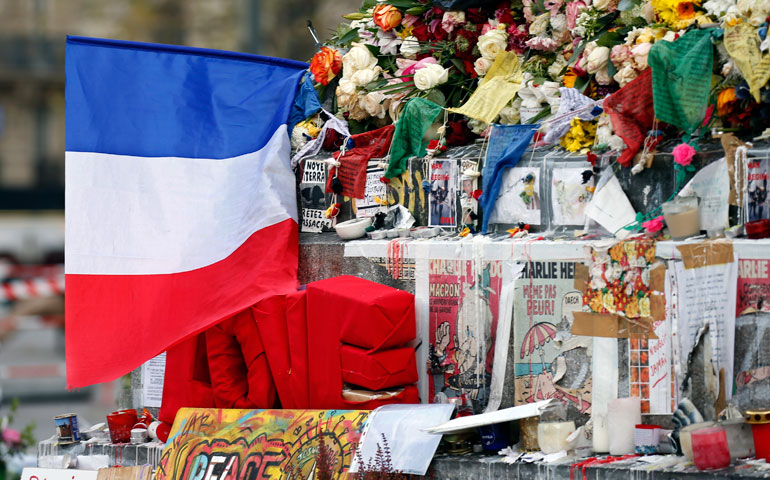 A French flag is seen among candles, flowers and messages in tribute to victims at the Place de la Republique in Paris Nov. 26. (Newscom/Reuters/Charles Platiau)