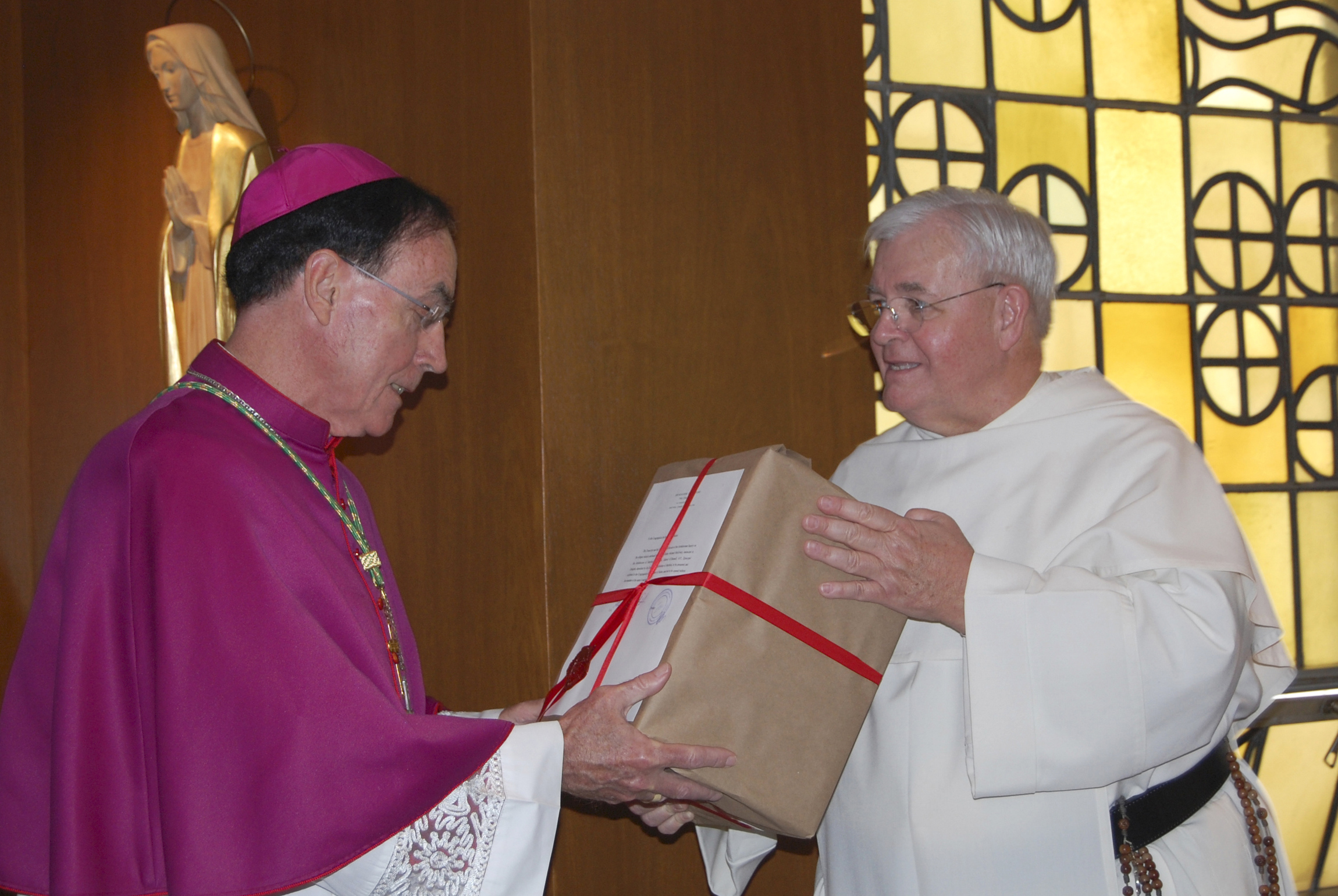 Archbishop Henry Mansell of Hartford, Conn., left, receives from Dominican Fr. Gabriel O'Donnell documents containing new evidence of an alleged miracle attributed to the founder of the Knights of Columbus, Fr. Michael McGivney, during a ceremony in 2009. (CNS/Catholic Transcript/Jack Sheedy)