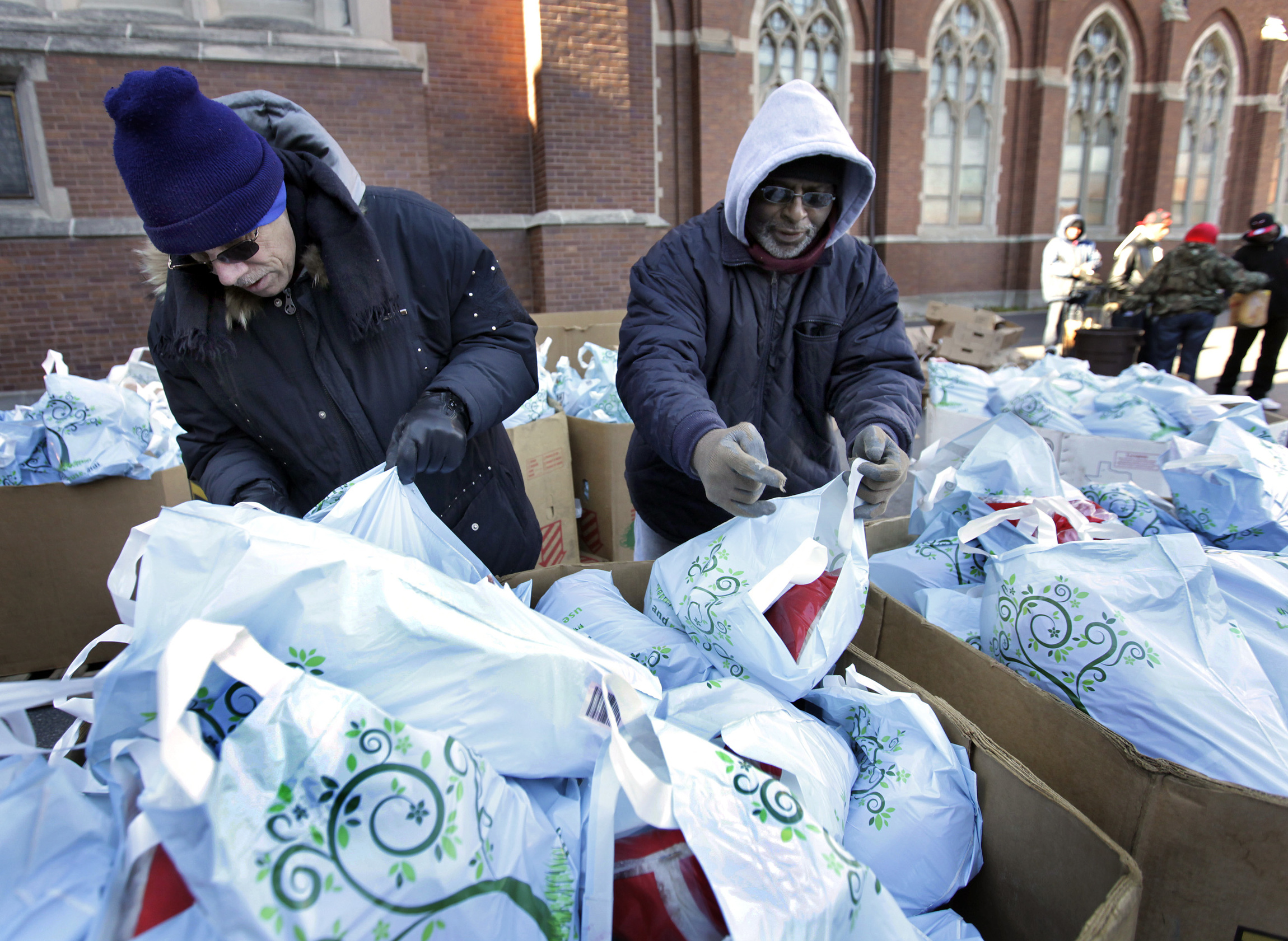 Parishioners Norman Smith and Richard King sort through turkeys to pass out to those in need Nov. 27 to feed near 600 families for Thanksgiving at St. Columbanus Church in Chicago. (CNS/Catholic New World/Karen Callaway)