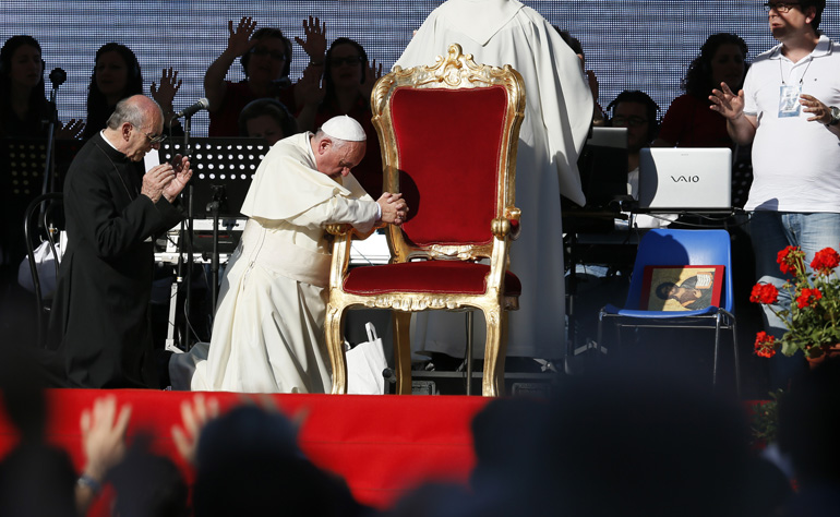 Pope Francis kneels as the crowd prays over him by singing and speaking in tongues during an encounter with more than 50,000 Catholic charismatics at the Olympic Stadium in Rome June 1. During the event the pope acknowledged he had once been uncomfortable with the charismatic movement. (CNS photo/Paul Haring) (June 2, 2014)
