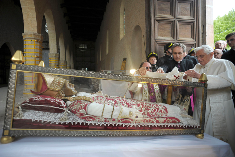 Pope Benedict XVI places a white stole on the remains of St. Celestine V, a 13th-century pope, during his 2009 visit to the earthquake-damaged Basilica of Santa Maria di Collemaggio in L'Aquila, Italy. St. Celestine was the last pope to voluntarily resig n before Pope Benedict stepped down in February 2013. (CNS/Reuters/L'Osservatore Romano) 