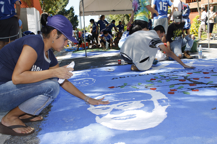 Ivette Escobar, a student at Central American University in San Salvador, helps to finish a rug Nov. 15, 2014, in honor of the victims in the 1989 murder of six Jesuits, their housekeeper and her daughter on the UCA campus. It was part of the 25th anniversary commemoration of the Jesuit martyrs. (CNS/Edgardo Ayala)