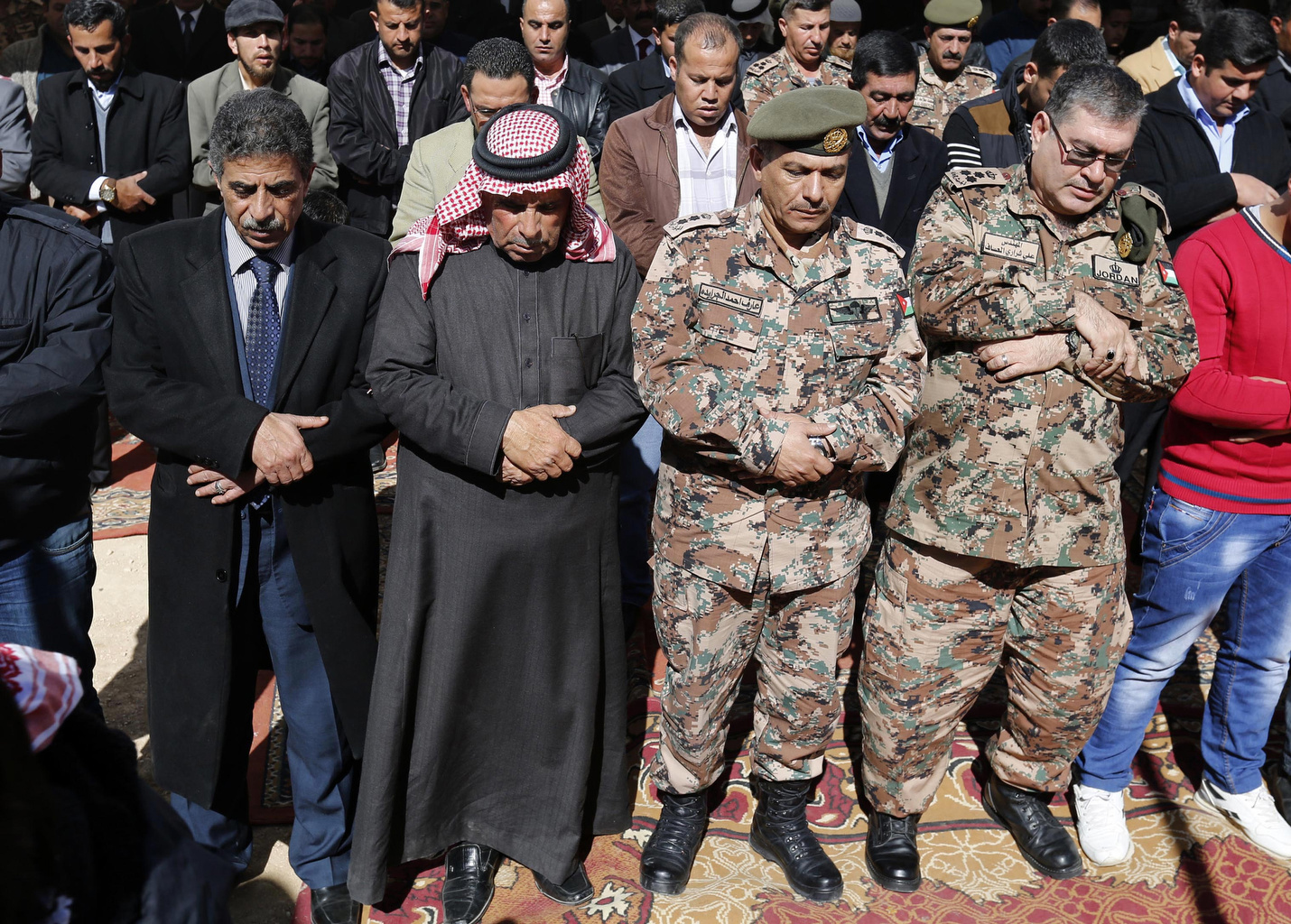 Saif al-Kasasbeh, second from left, father of First Lt. Muath al-Kasasbeh, a murdered Jordanian pilot, prays in Jordan Feb. 4 with other mourners during an event commemorating the pilot's death at the hands of Islamic State militants. (CNS/EPA/Jasmal N asrallah) 