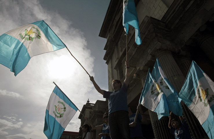 Guatemalan demonstrators wave national flags as they ask Guatemalan President Otto Perez Molina to resign during a protest in front of the National Palace of Culture in Guatemala City Aug. 22. (CNS/Esteban Biba, EPA)