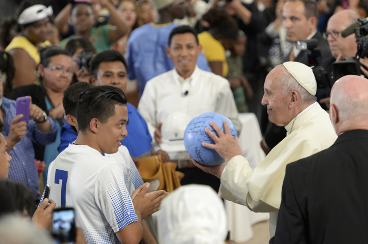 Pope Francis accepts an autographed soccer ball from the student team at Our Lady Queen of Angels School in the East Harlem area of New York Sept. 25. (CNS photo/Debbie Egan-Chin, pool)
