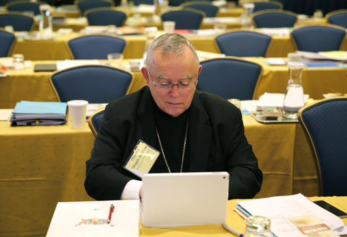 Archbishop Charles J. Chaput of Philadelphia works on his laptop during a break at the 2015 fall general assembly of the U.S. Conference of Catholic Bishops in Baltimore Nov. 17. (CNS/Bob Roller)