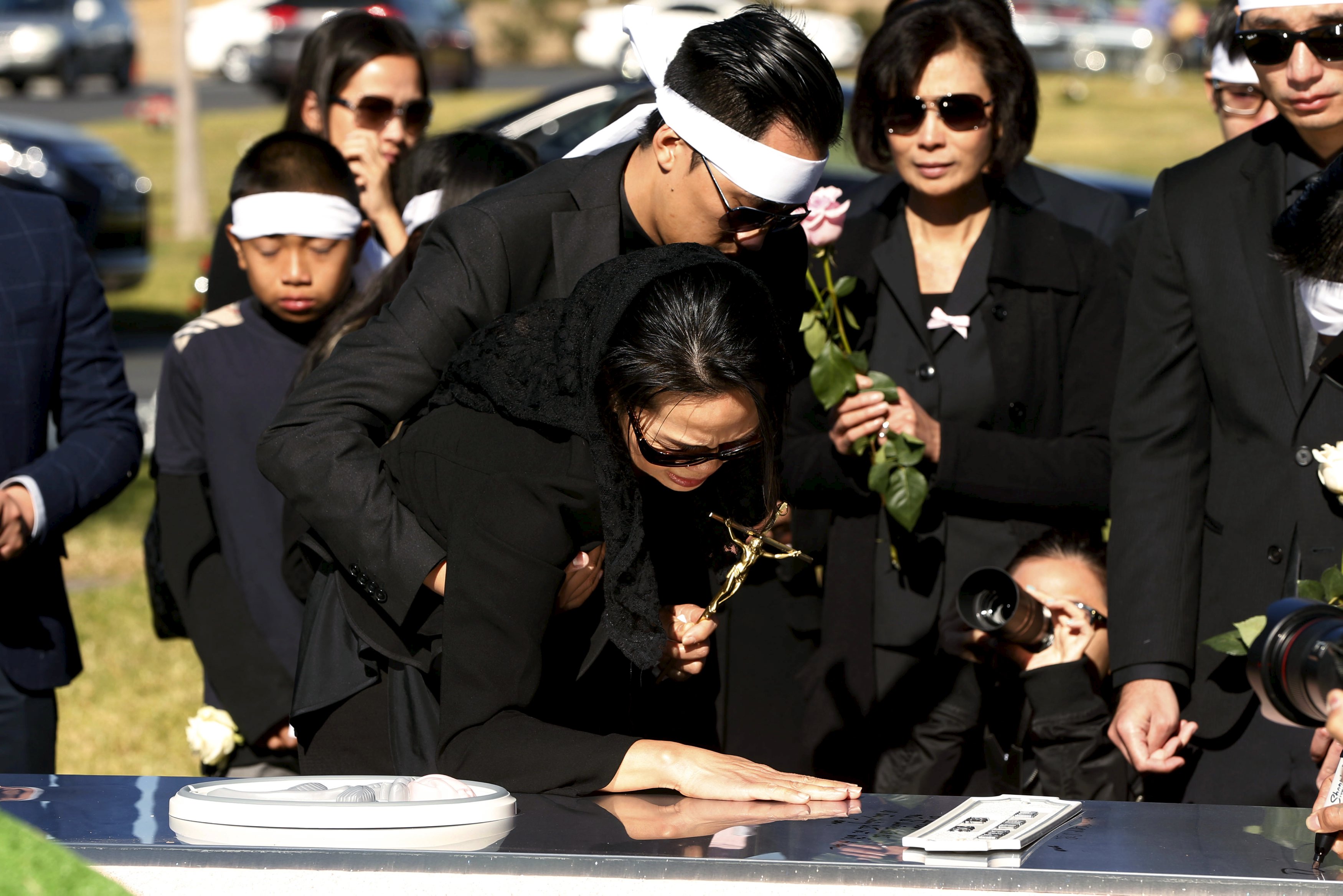 Van Thanh Nguyen touches the burial vault of her daughter, Tin Nguyen, during her Dec. 12 burial at Good Shepherd Cemetery in Huntington Beach, Calif. (CNS/Patrick T. Fallon, Reuters)