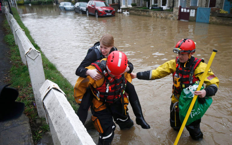 Members of the emergency services rescue a woman from a flooded property in York City Center in northern England. (CNS photo/Andrew Yates, Reuters)