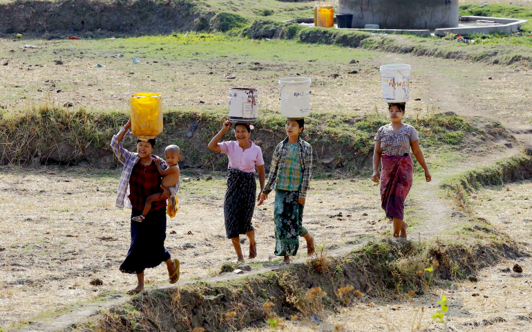 Women carry drinking water near Naypyitaw, Myanmar, in April 2016. (CNS/EPA/Hein Htet)