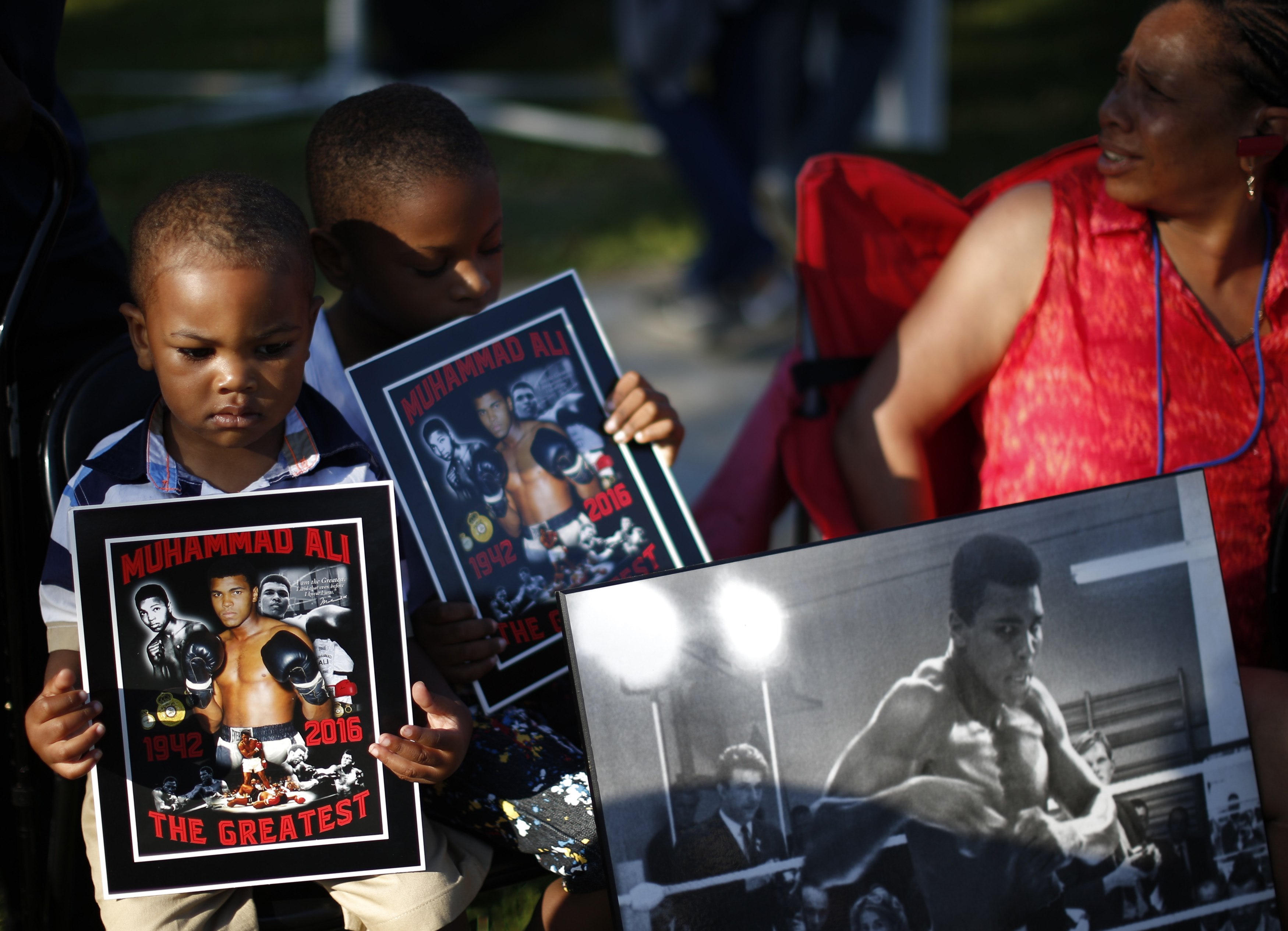 Two boys hold an image of Muhammad Ali during the June 10 funeral procession for the activist, athlete and humanitarian in Louisville, Ky. Ali died June 3 at age 74. (CNS/Reuters/Lucy Nicholson)