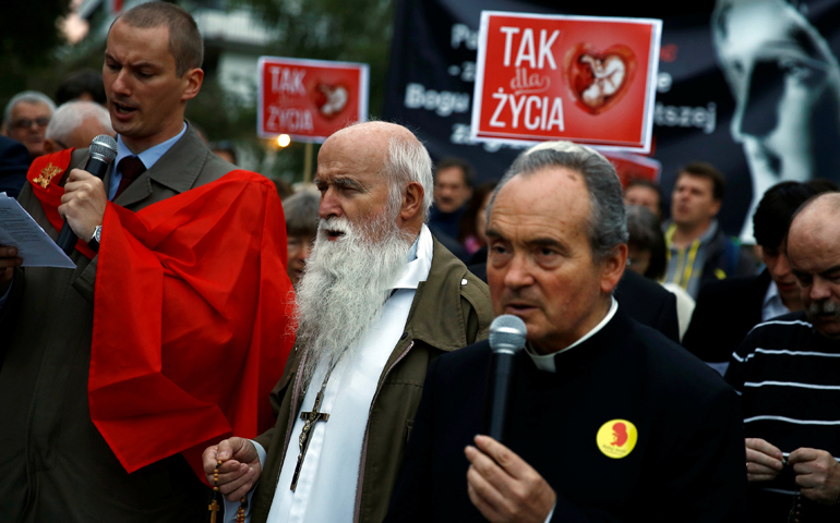 A clergyman and others pray as they take part in Sept. 22 pro-life rally in front of the parliament in Warsaw, Poland. Banners read: "Yes for life." (CNS/Kacper Pempel, Reuters)
