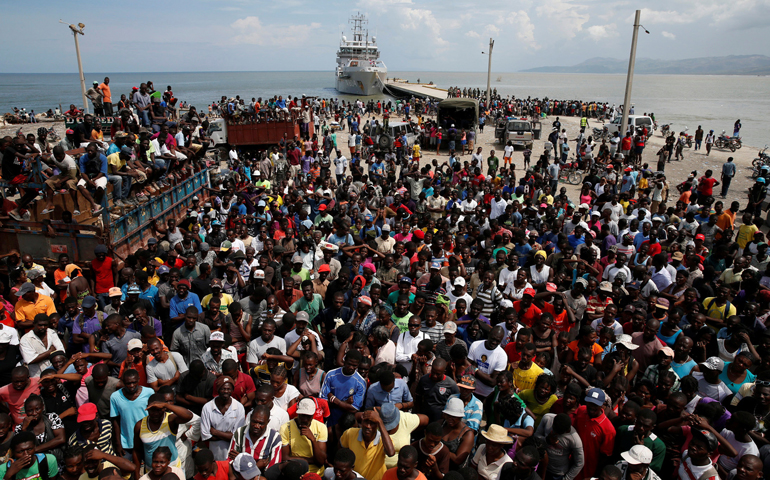 People in Jeremie, Haiti, wait for relief to be unloaded from a Dutch navy ship Oct. 16. (CNS/Carlos Garcia Rawlins, Reuters)