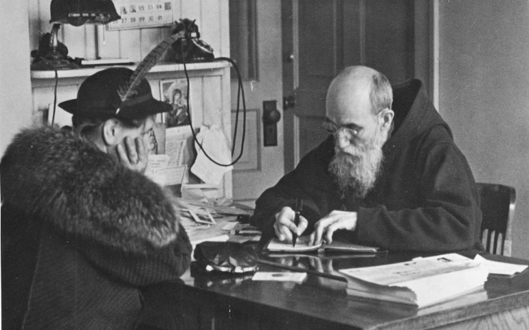 Fr. Solanus Casey records a note from a woman who visited him at St. Bonaventure Monastery in Detroit in 1941. The Capuchin Franciscan friar kept dozens of notebooks filled with prayer requests and favors from the thousands who visited him each year. (CNS / Detroit Archdiocese)