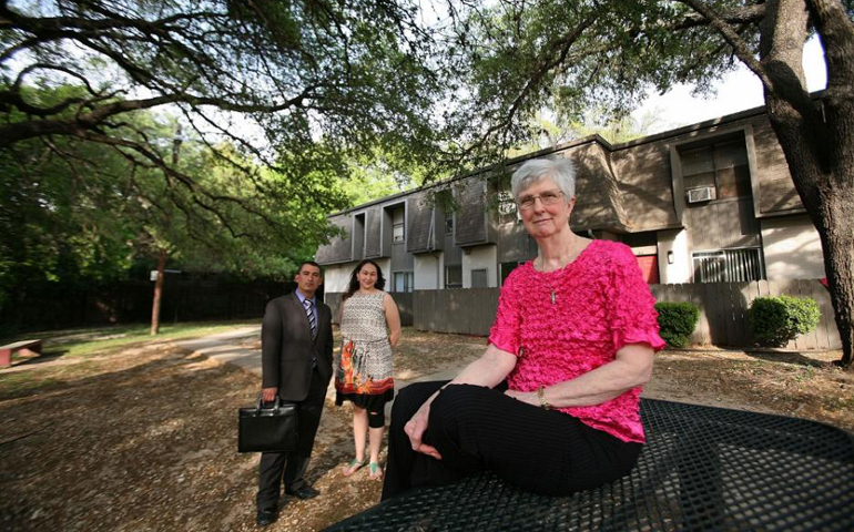 Sr. Christine Stephens, co-director of the West/Southwest Industrial Areas Foundation, sits at the Oak Creek Village Apartments in Austin, Texas. Behind her is Jacob Cortes, lead organizer for Austin Interfaith, the foundation member organization that empowered Koreena Malone, center, to preserve the 173 affordable units in her apartment complex. (Nuri Vallbona)