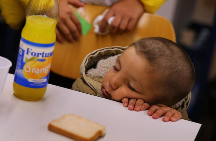 A refugee child from Iraq falls asleep at a table inside a shelter in Wertheim, Germany, Sept. 14. "Do not abandon victims" of conflicts in Syria and Iraq, Pope Francs said. (CNS photo / Karl-Josef Hildenbrand, Reuters)