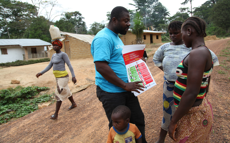 A man in Lofa, Liberia, educates villagers in late April on the prevention of Ebola disease. (CNS/EPA/Ahmed Jallanzo)